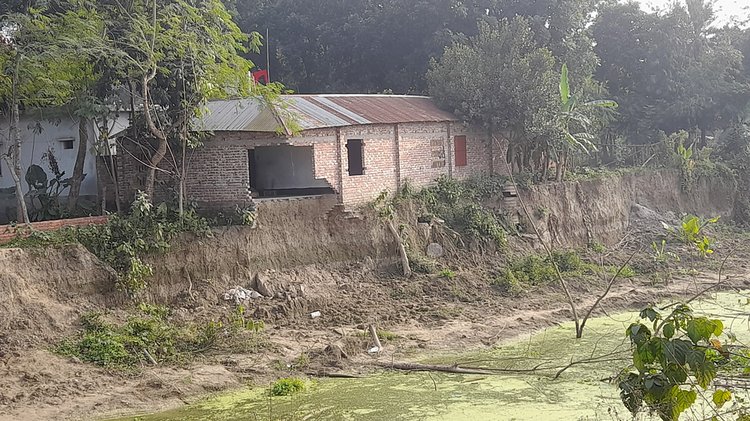 ঝিনাইদহের মকিমপুর এলাকায় খালে ধসে পড়ার উপক্রম একটি বাড়ি। ছবি: আজকের পত্রিকা